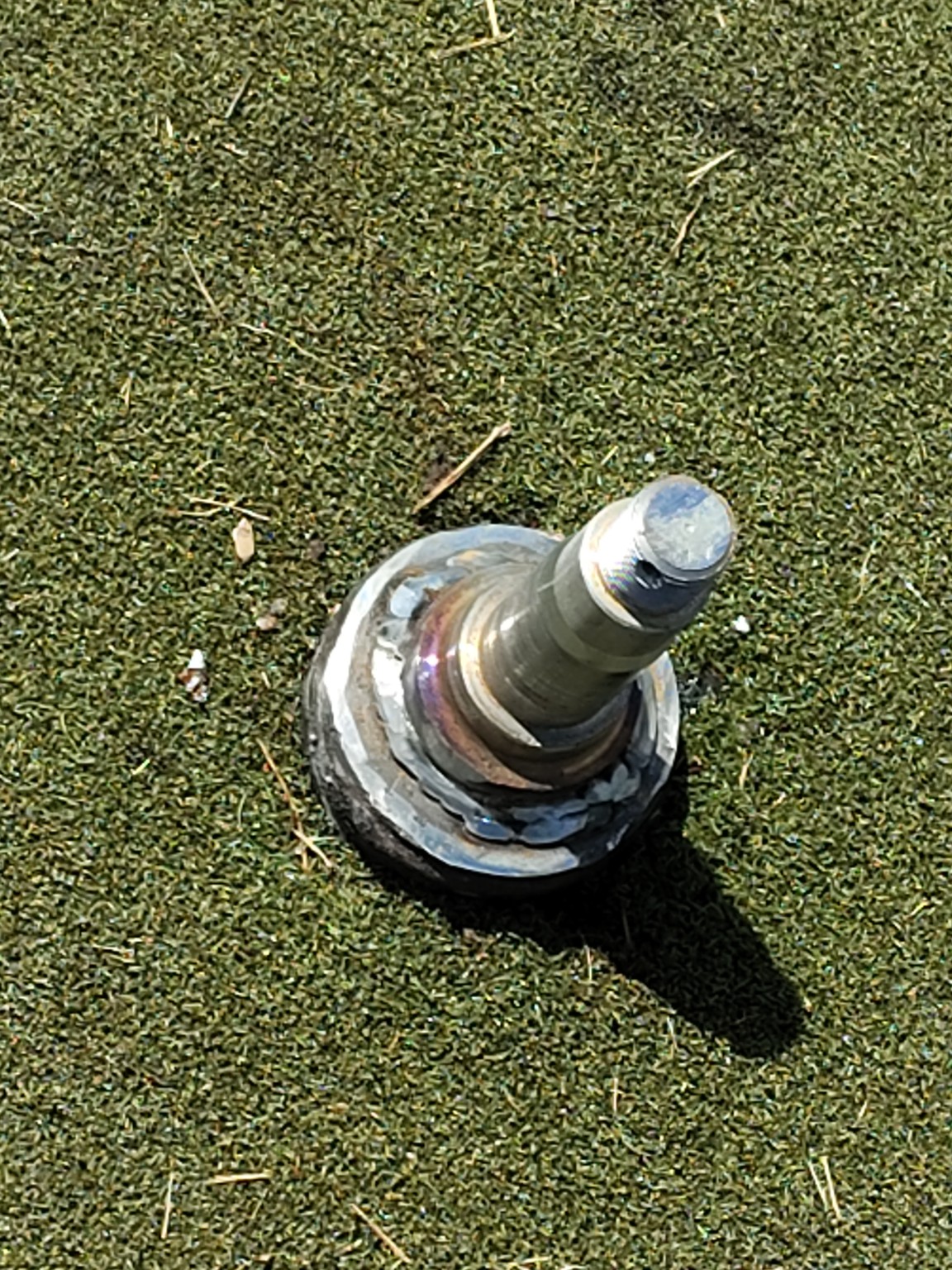 Metal component placed on grass after welding